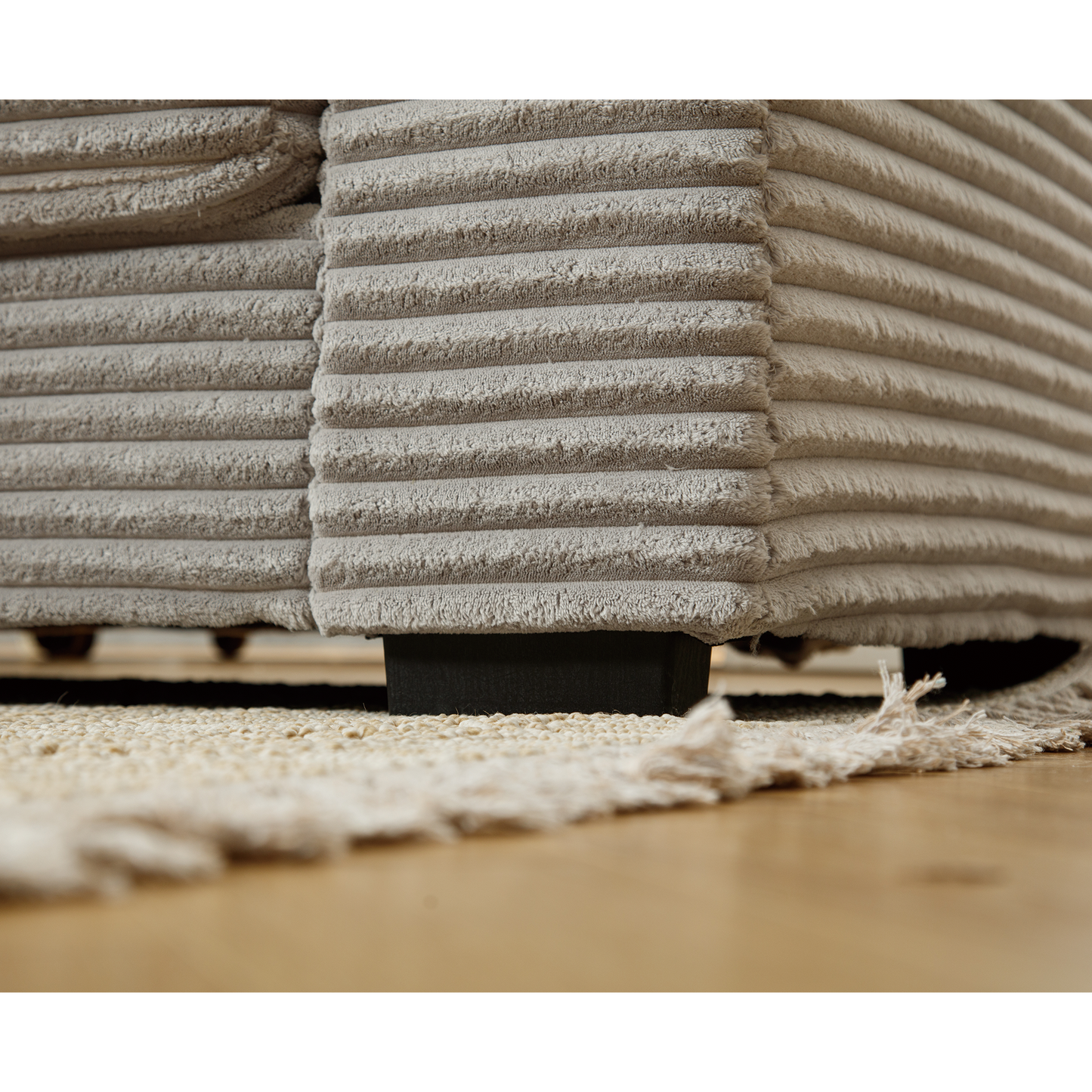 Closeup of plush grey corduroy sofa fabric texture showing horizontal ridges