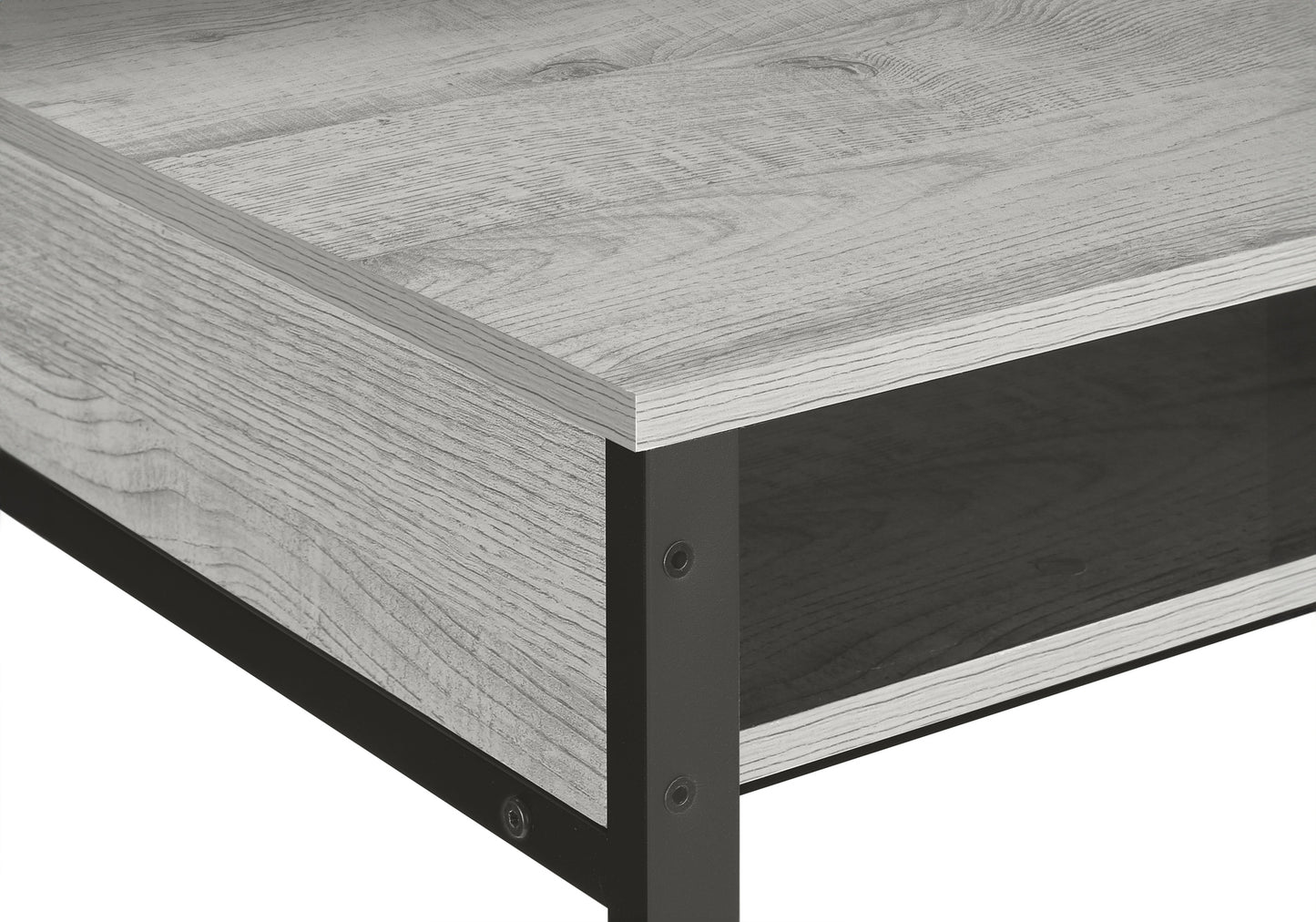 Closeup of a rustic grey wood coffee table surface with black metal legs and an open shelf