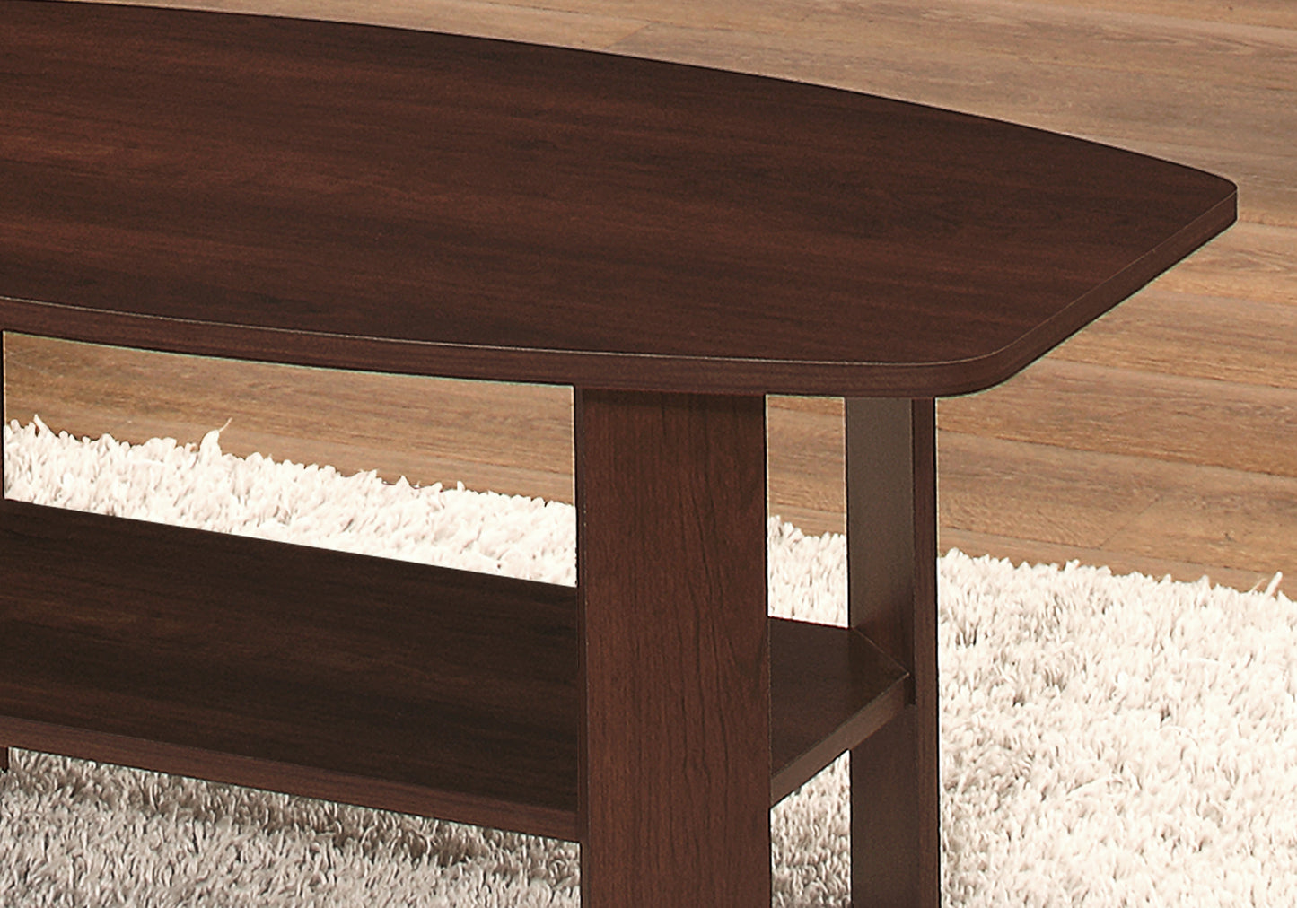 Dark wood oval coffee table with lower shelf on fluffy rug
