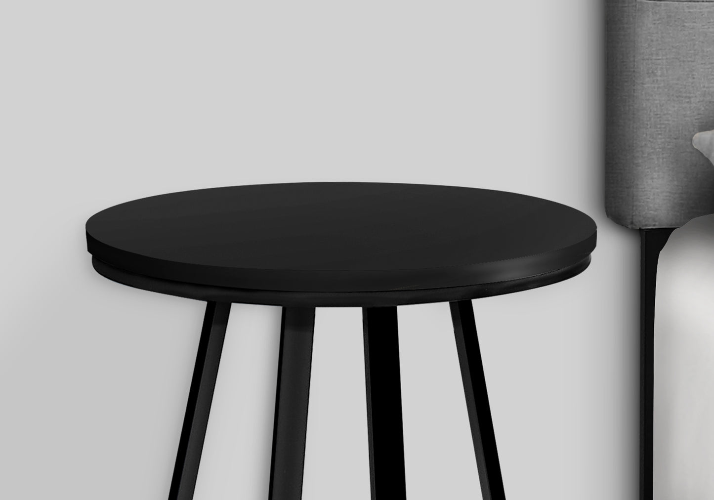 Sleek black round side table with tapered legs
