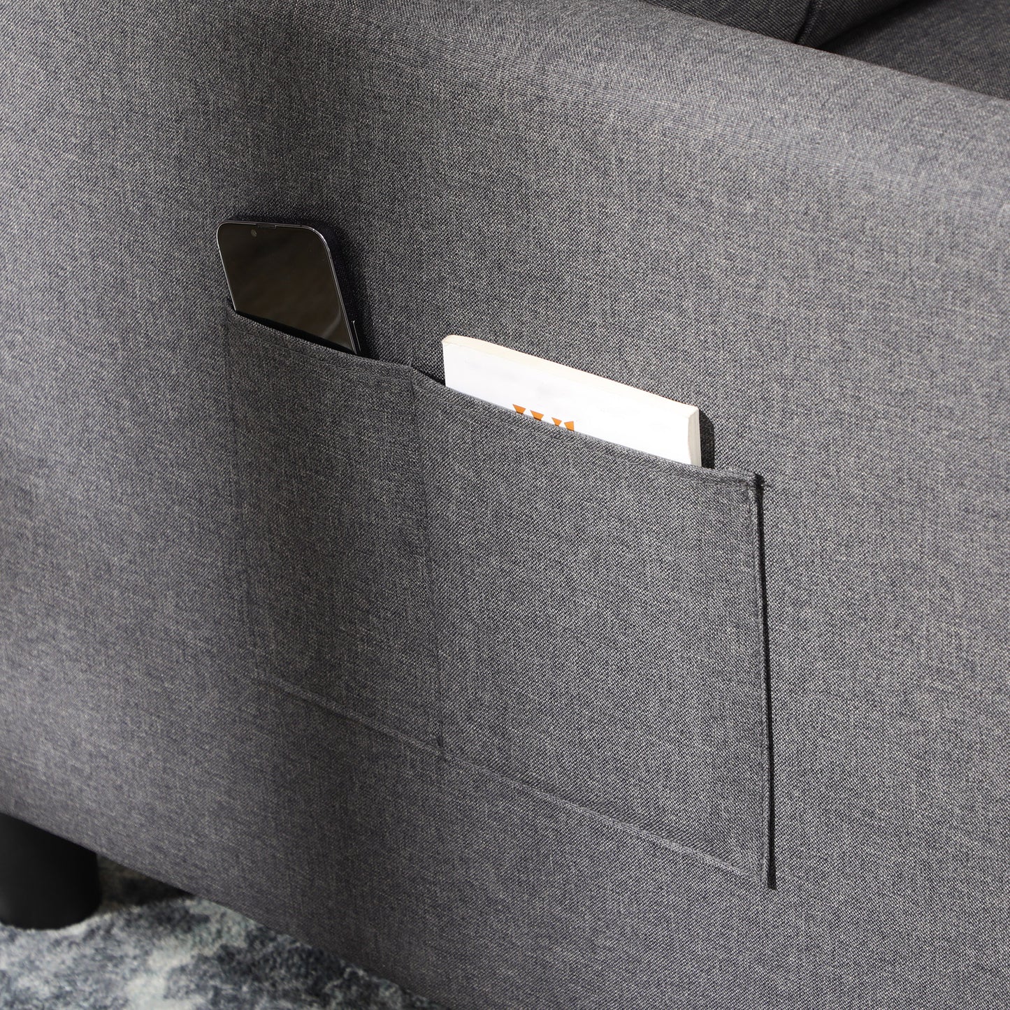 Dark grey fabric sofa with integrated phone and book pocket