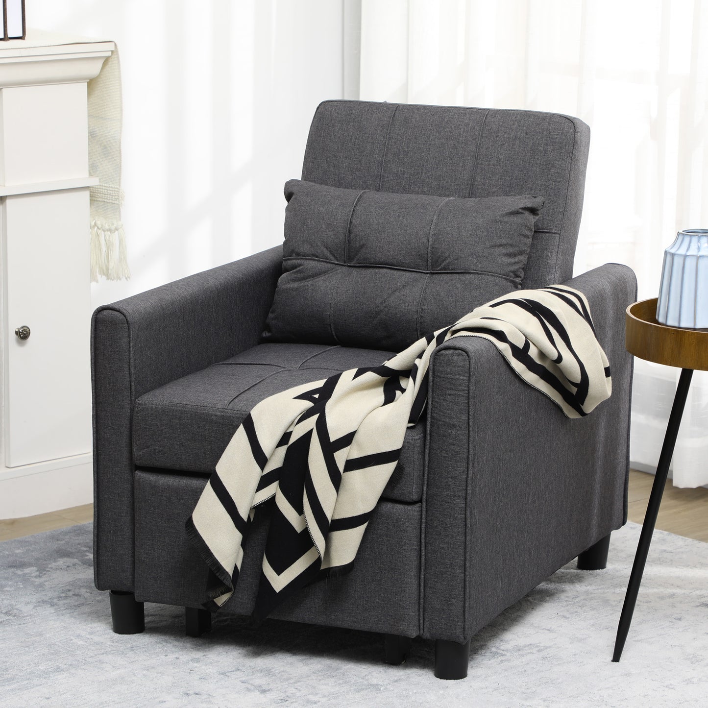 Dark gray upholstered accent chair with tufted back and matching throw pillow