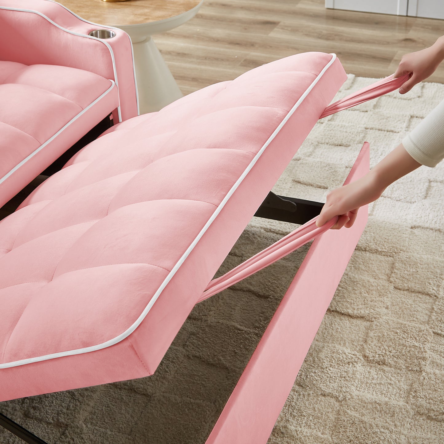 Pink velvet sofa with tufted cushions and white piping being pulled out