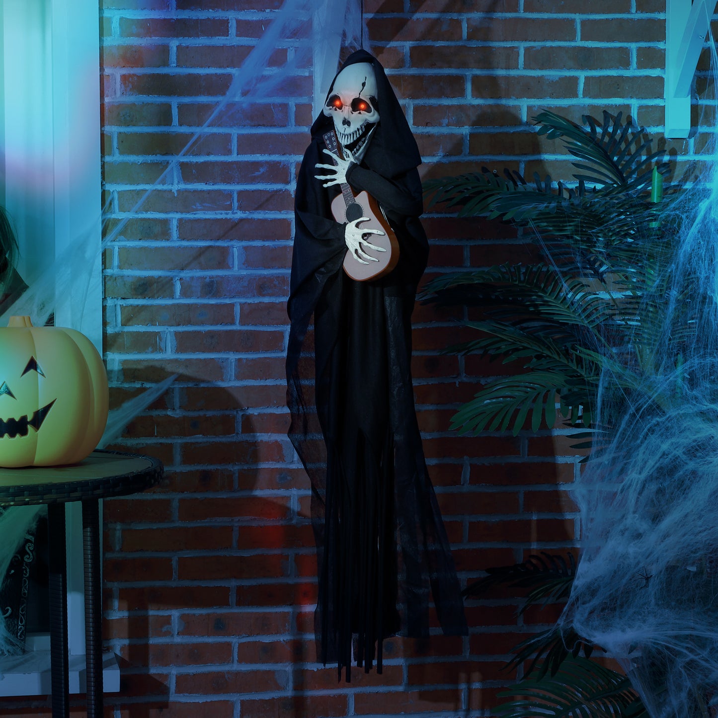 Hanging grim reaper prop with red glowing eyes holding a brown ukulele