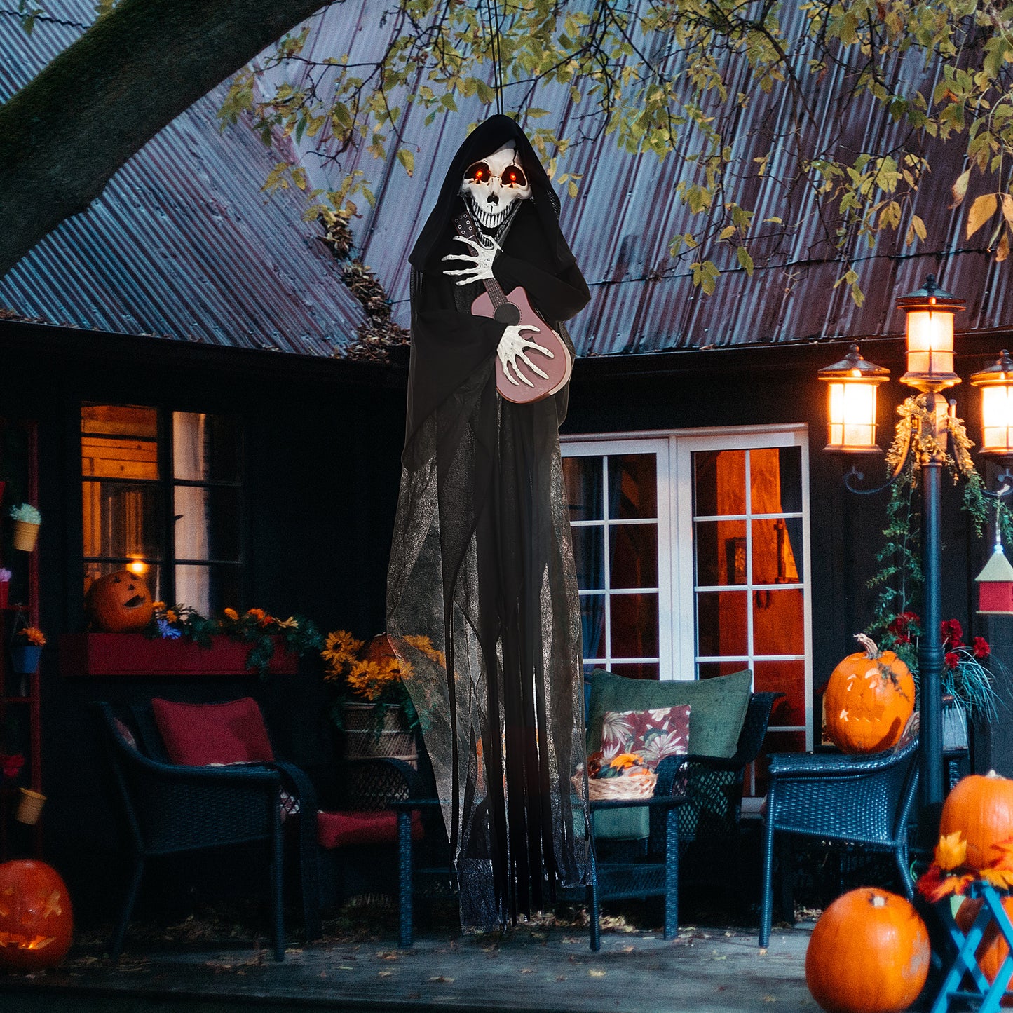 Hanging grim reaper Halloween decoration holding a pink guitar with glowing red eyes