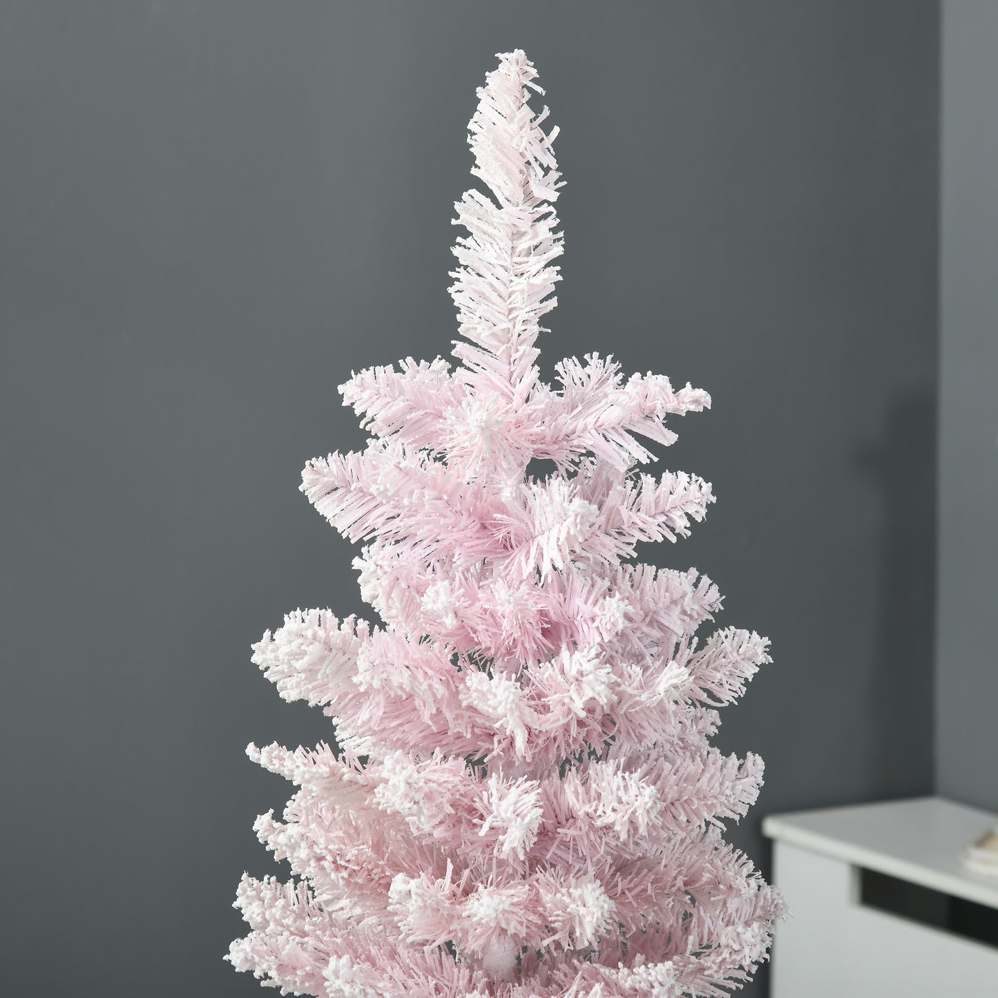 Closeup of a fluffy pink artificial Christmas tree with frosted tips