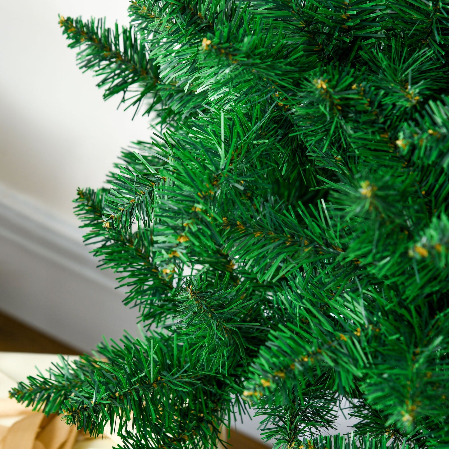 Closeup of lush green artificial Christmas tree branches with subtle gold accents