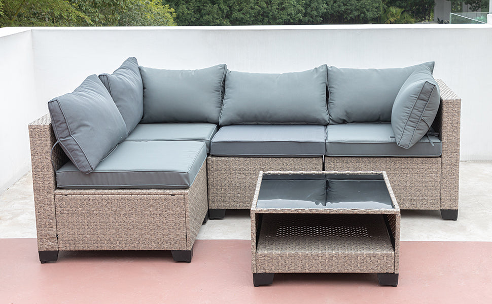 Wicker sectional patio sofa with grey cushions and a glasstop coffee table