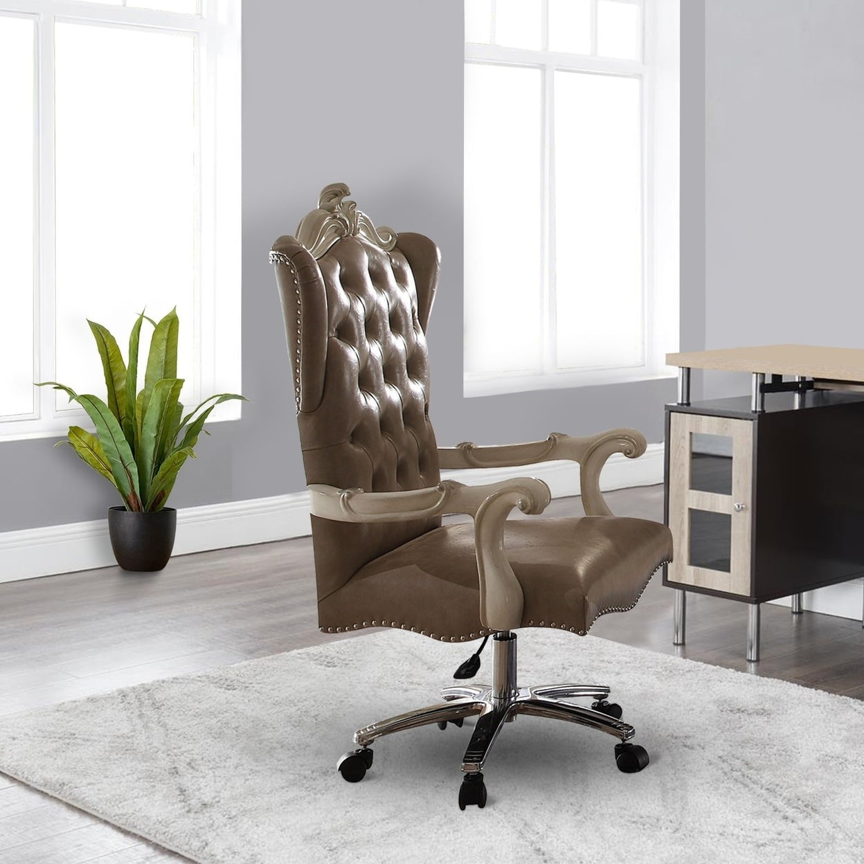 Tufted brown leather executive chair with silver nailhead trim and ornate carved arms