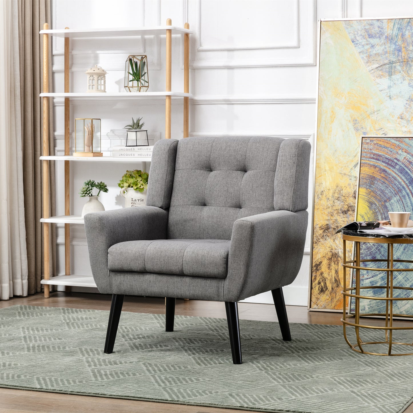 Grey upholstered accent chair with tufted back and black tapered legs
