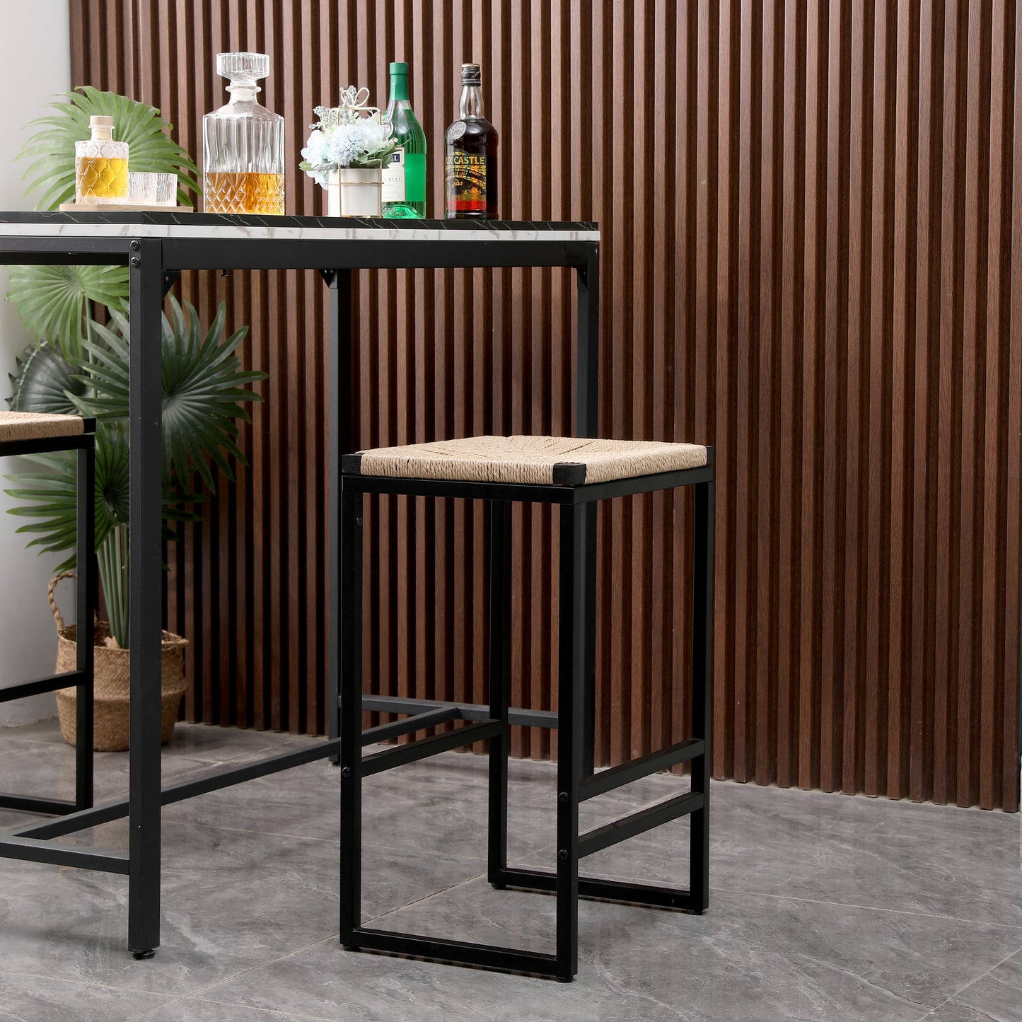 Black metal bar stool with woven natural fiber seat and footrest
