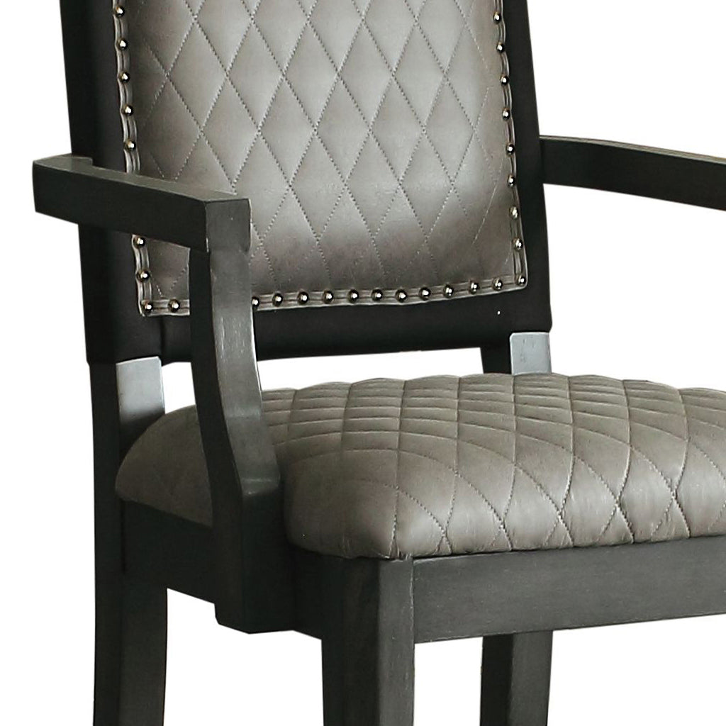 Dark gray upholstered dining chair with diamond tufting and nailhead trim