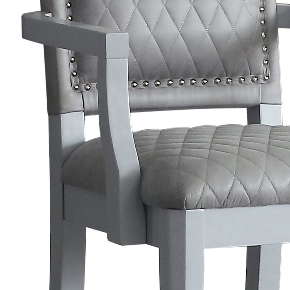 Grey tufted leather armchair with silver nailhead trim and wood frame