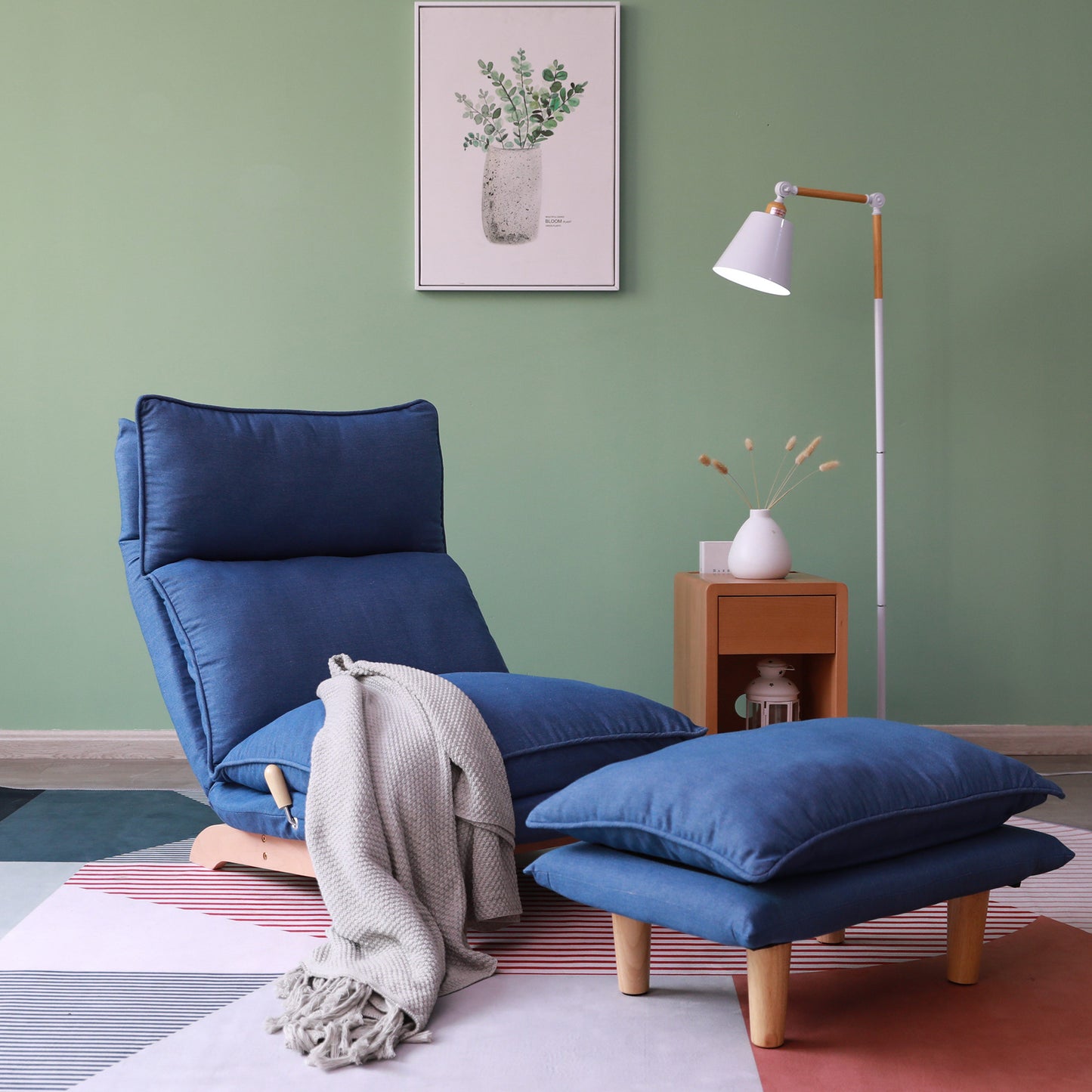 Navy blue upholstered floor chair with adjustable backrest and matching ottoman