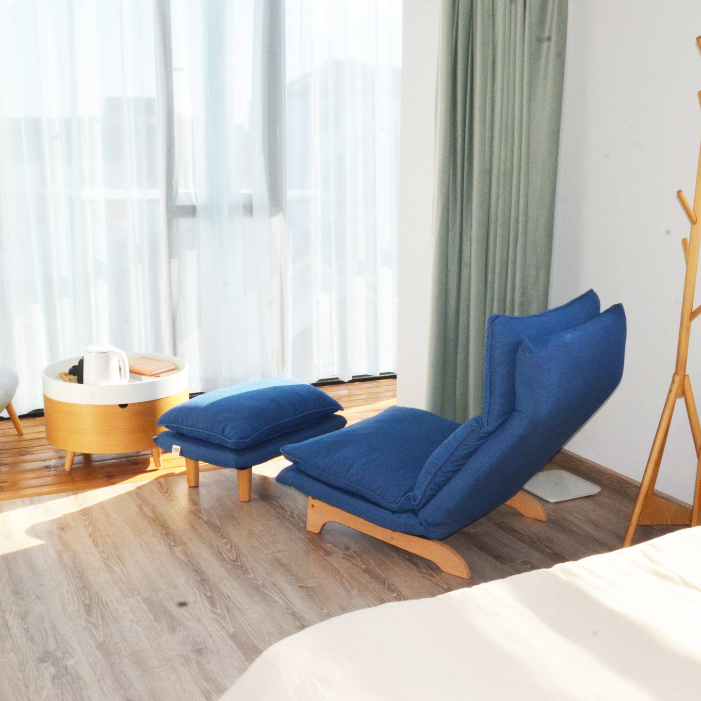 Blue adjustable lounge chair with matching ottoman on a wooden floor perfect for relaxation
