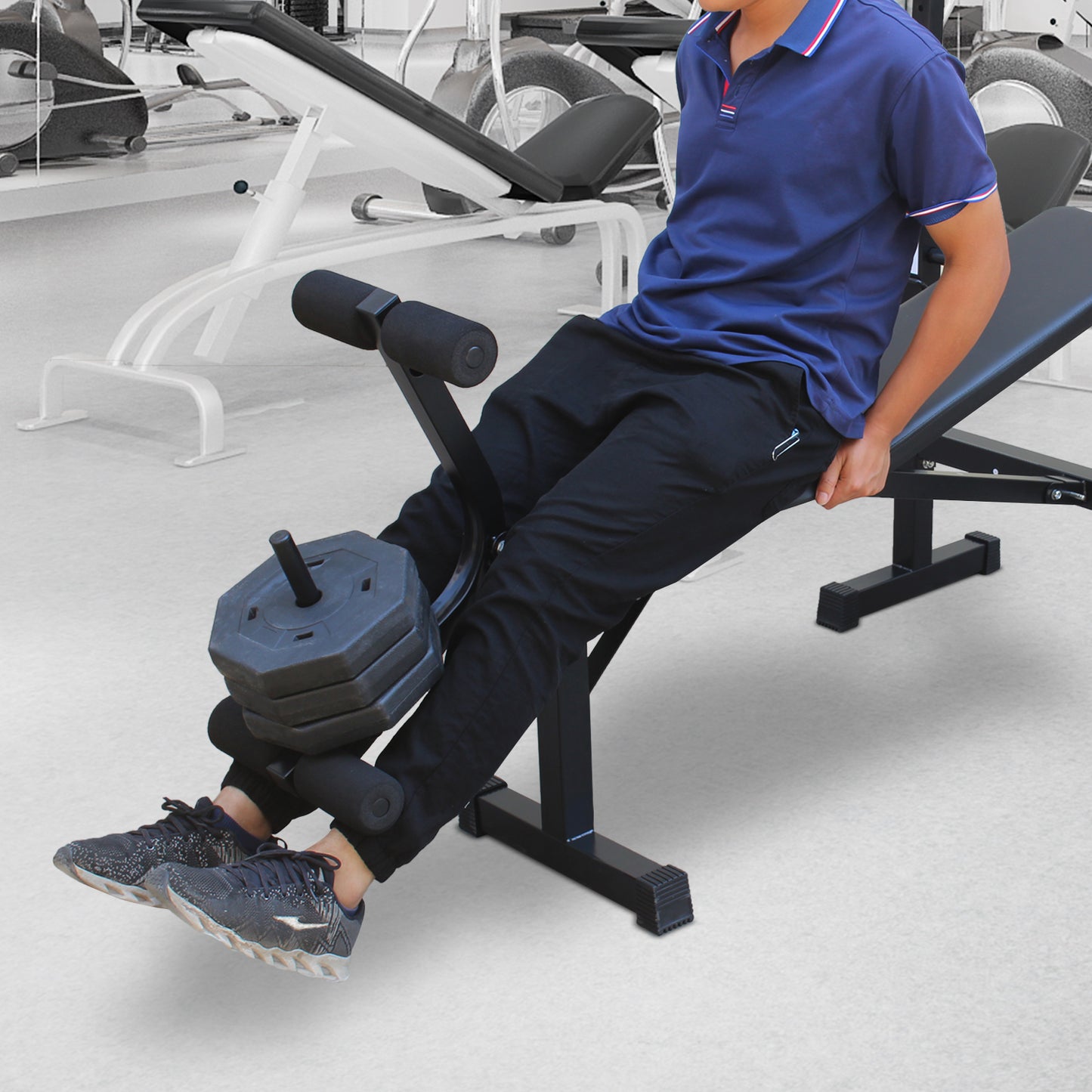 Black adjustable workout bench with padded leg rollers and weight plates
