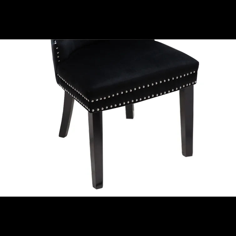 Black velvet dining chair with studded trim and dark wooden legs