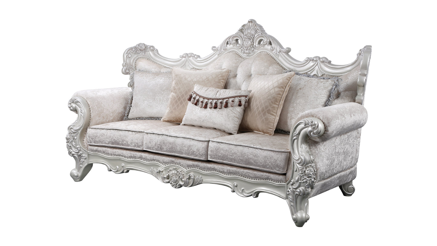 Ornate silver Louis XV style sofa upholstered in damask fabric with plush accent pillows