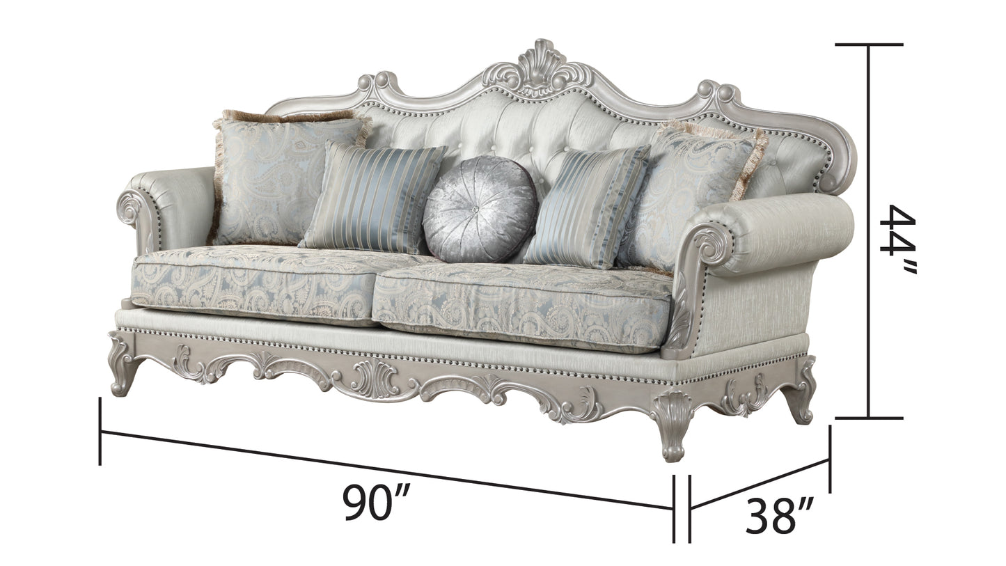 Ornate silver sofa with tufted back blue paisley cushions and decorative pillows