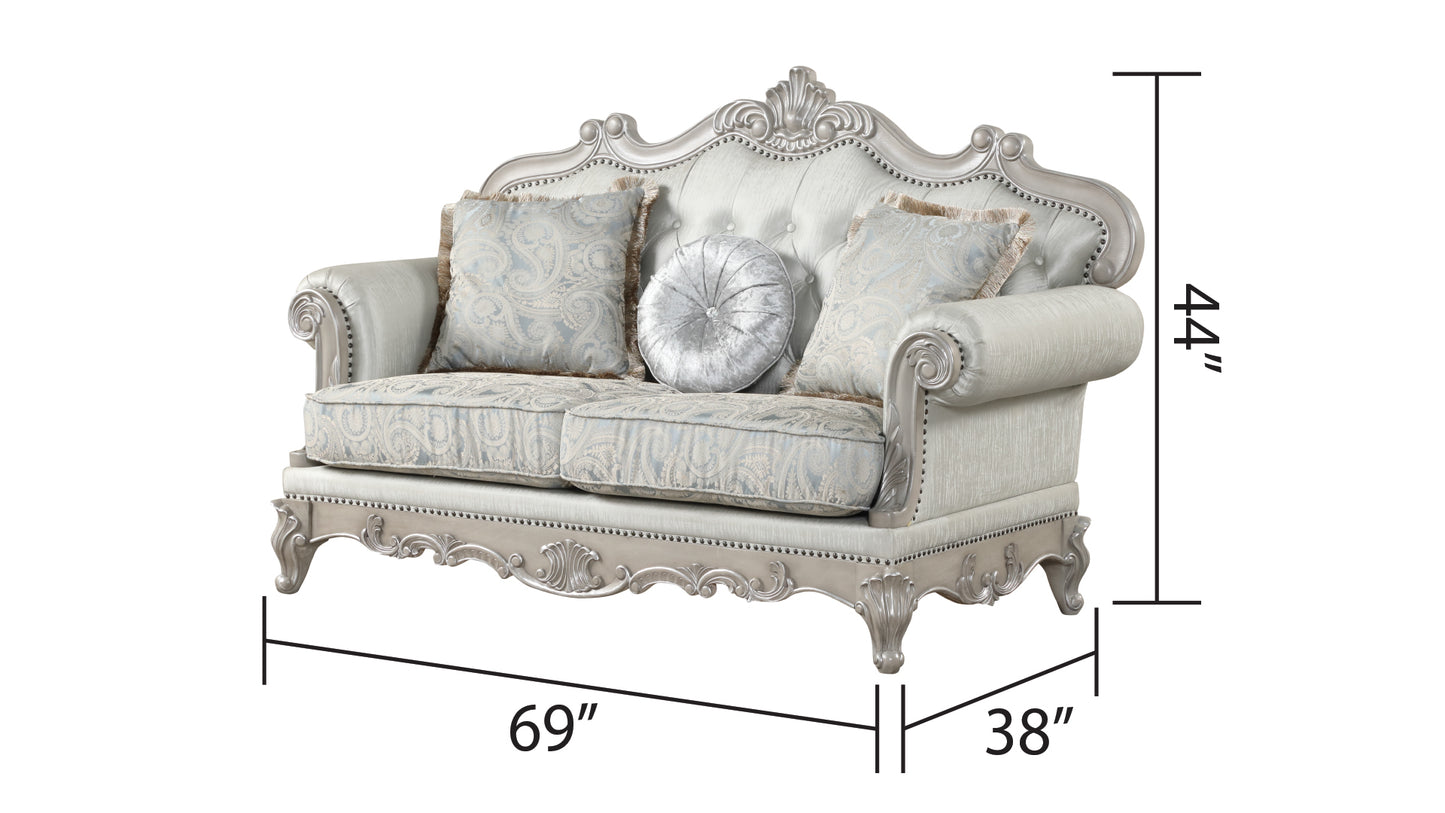 Silver upholstered loveseat with ornate detailing and paisley cushions