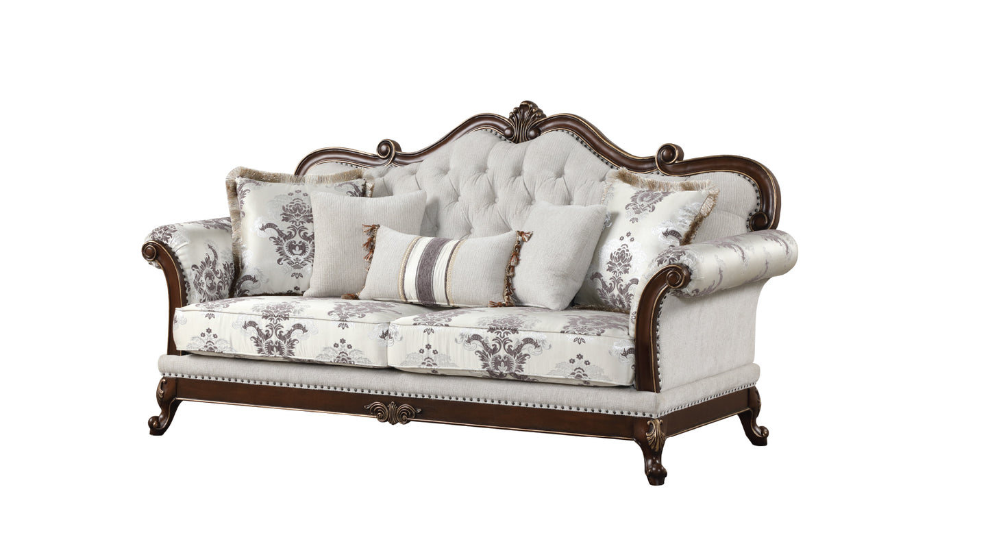 Elegant sofa with tufted cream back ornate wooden frame and damask patterned cushions