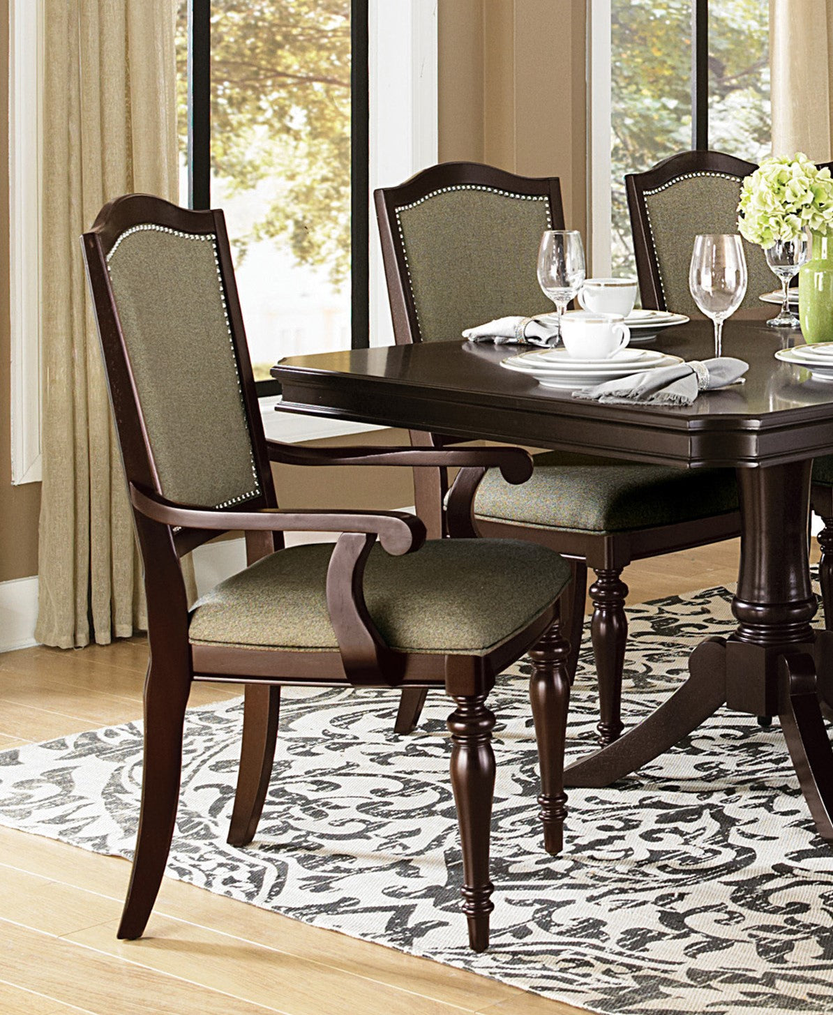 Dark wood dining chair with green upholstered seat and back nailhead trim