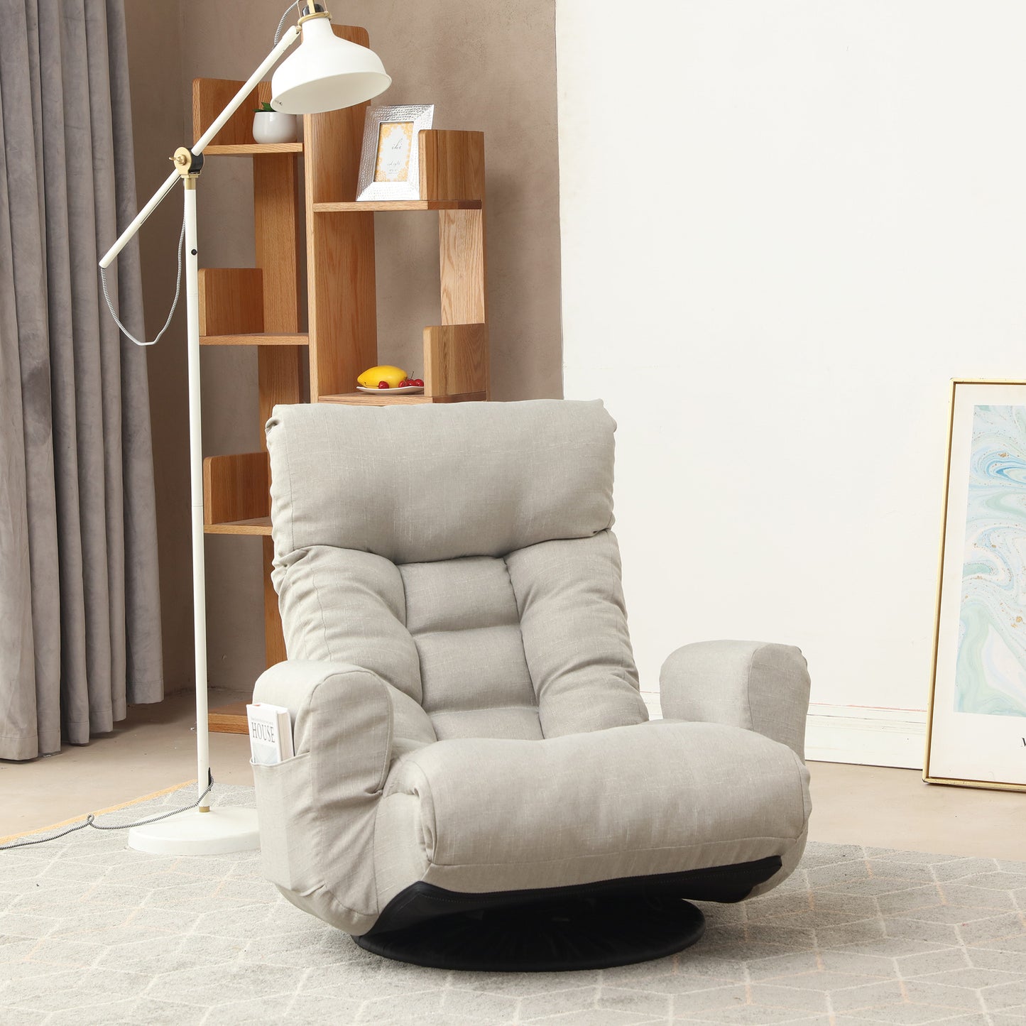 Comfortable light grey fabric armchair with plush cushions and builtin side pocket for magazines