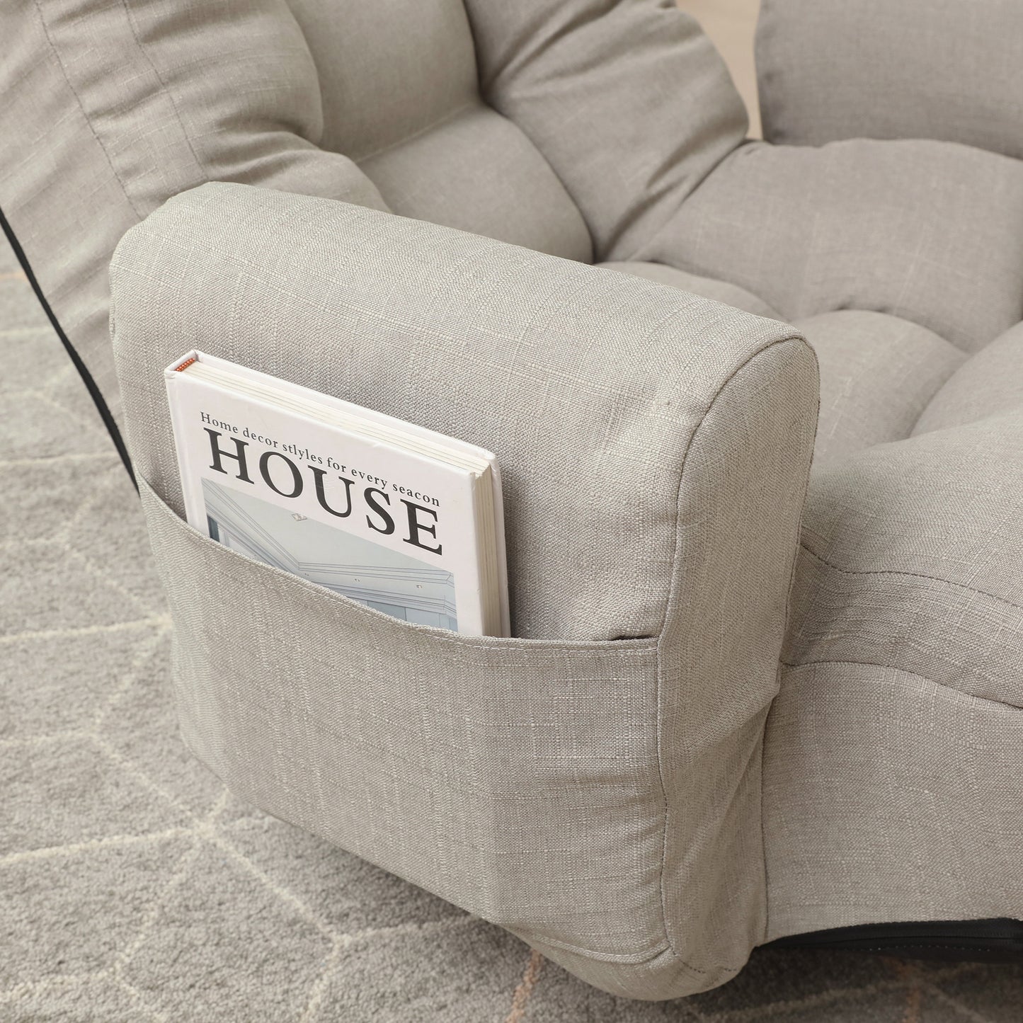 Light gray linen sofa armrest with builtin pocket holding a house decor magazine