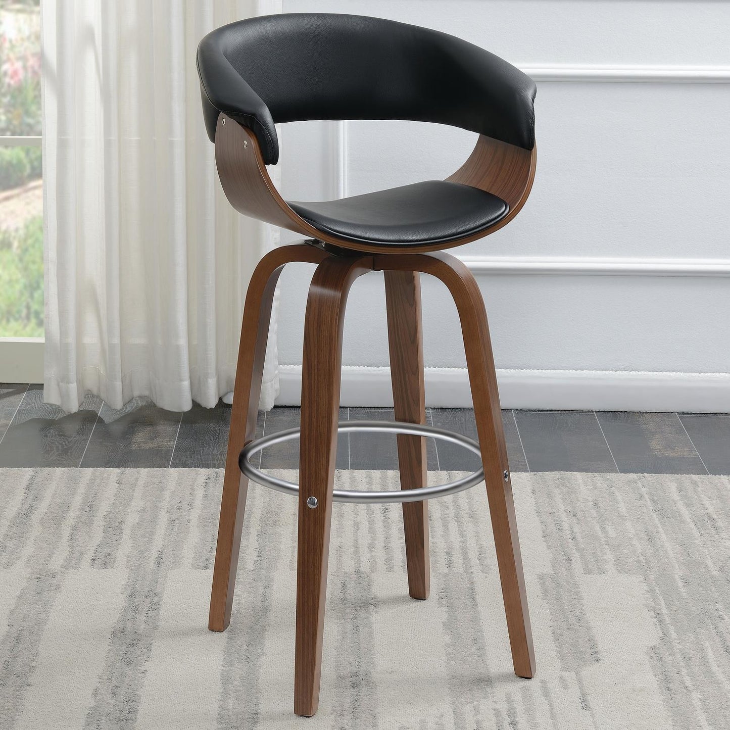 Black faux leather swivel bar stool with curved wood shell and walnut finish legs
