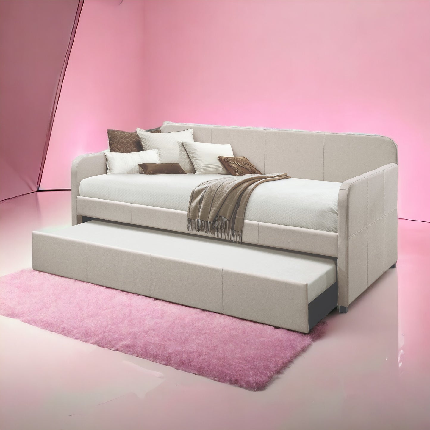 Modern beige upholstered daybed with trundle and decorative pillows