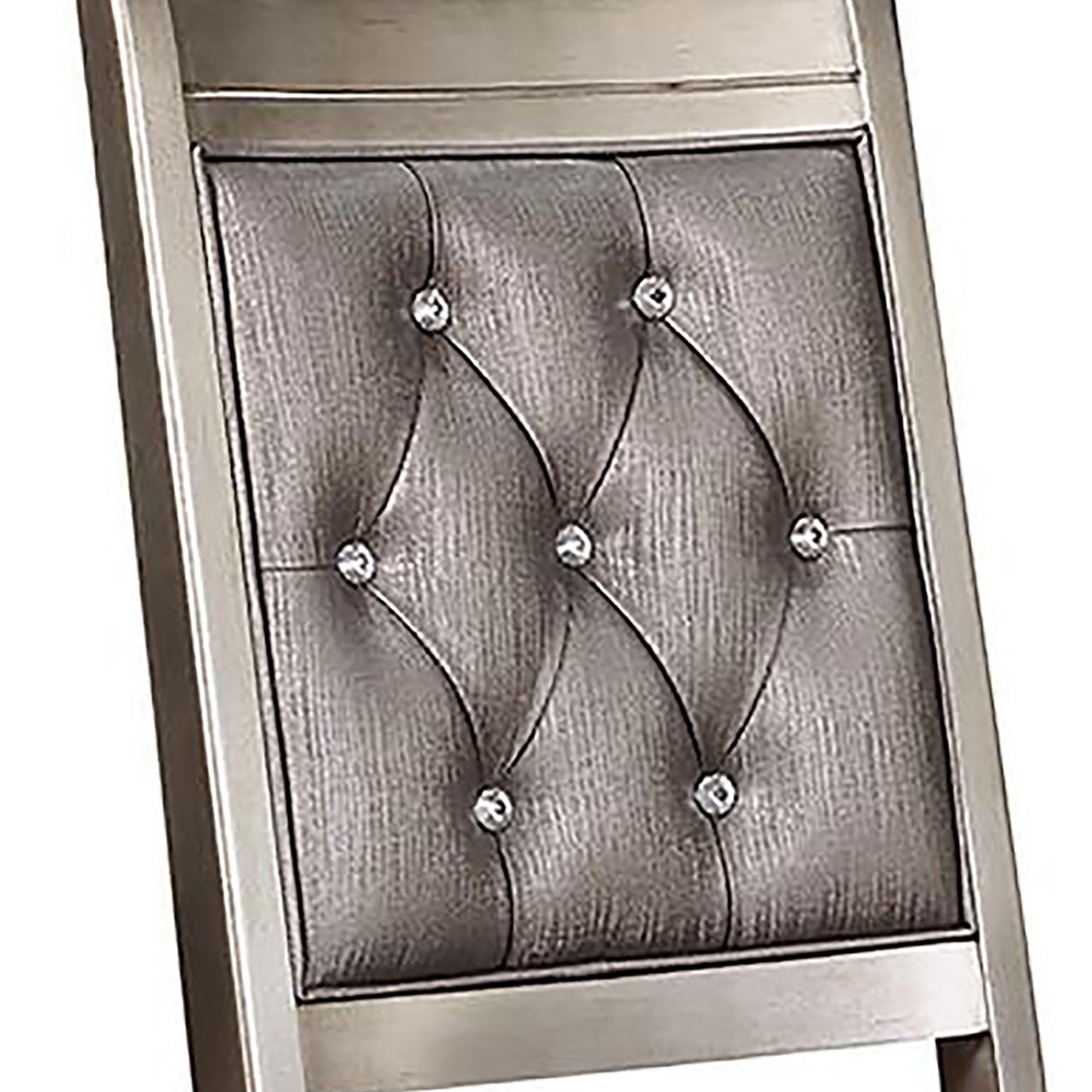 Closeup of a silver tufted headboard with crystal accents