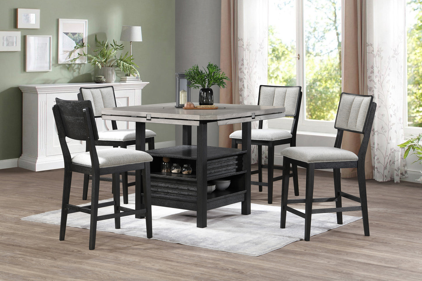 Four modern grey and black counter height chairs with upholstered seats around a dining table