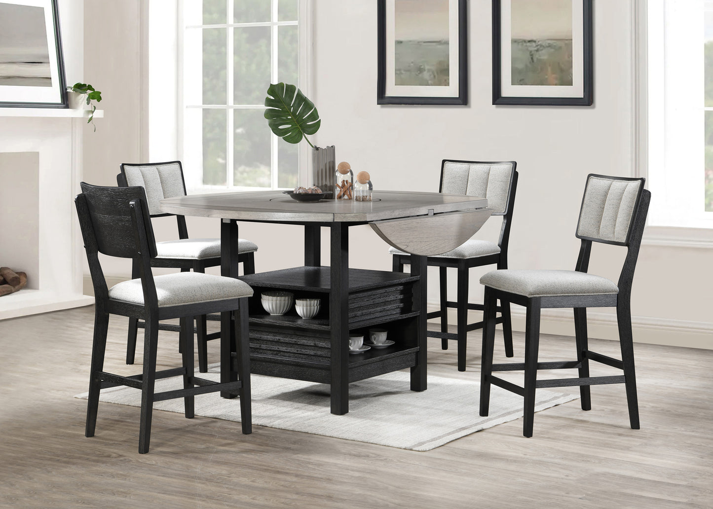 Expandable gray oak dining table with four black wood chairs featuring textured gray upholstery for a modern kitchen