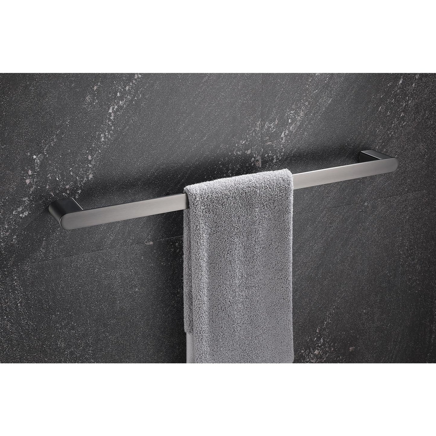 Sleek stainless steel towel bar holding a plush gray towel against a dark granite tiled wall