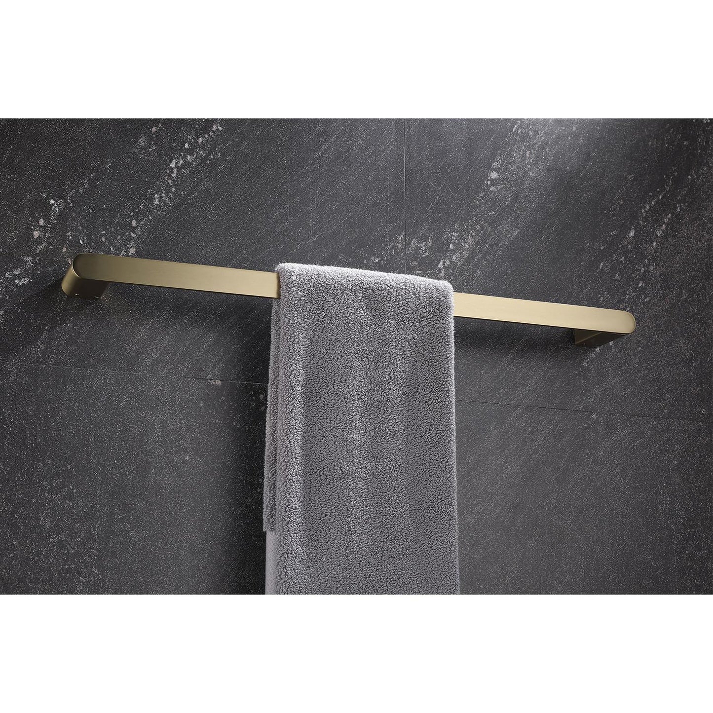 Modern brushed brass towel bar holding a grey bath towel