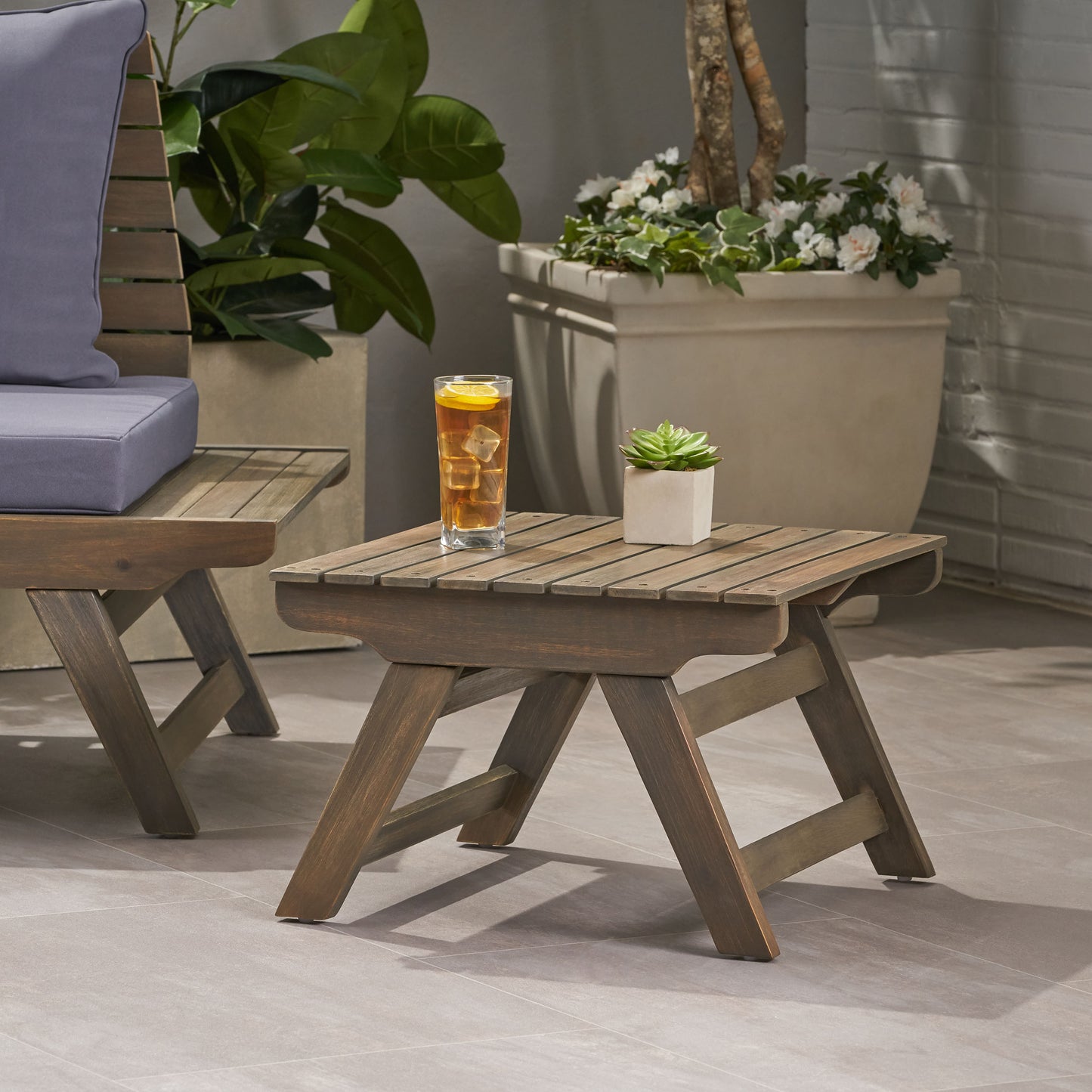 Rustic brown wooden outdoor side table with slatted top and Xframe legs