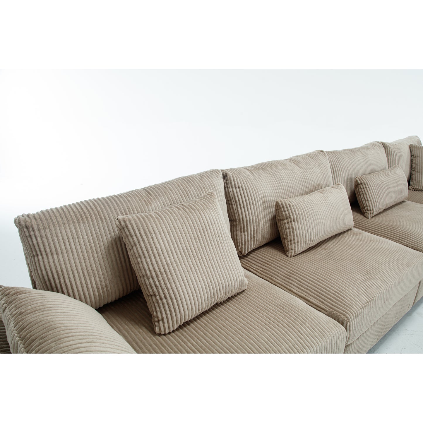 Plush beige corduroy sectional sofa with multiple accent pillows for comfort