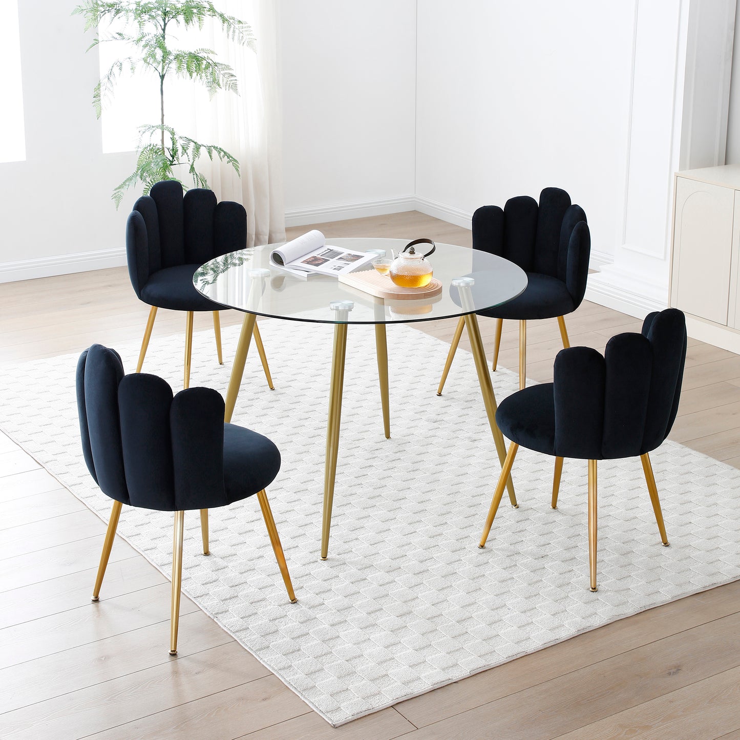 Elegant round glass top dining table with black velvet petal chairs and gold legs