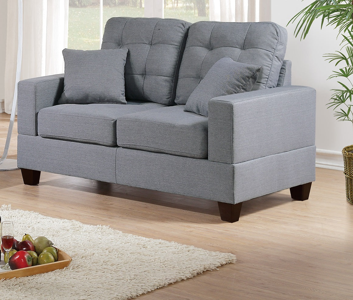 Tufted grey fabric loveseat with two throw pillows perfect for small living spaces