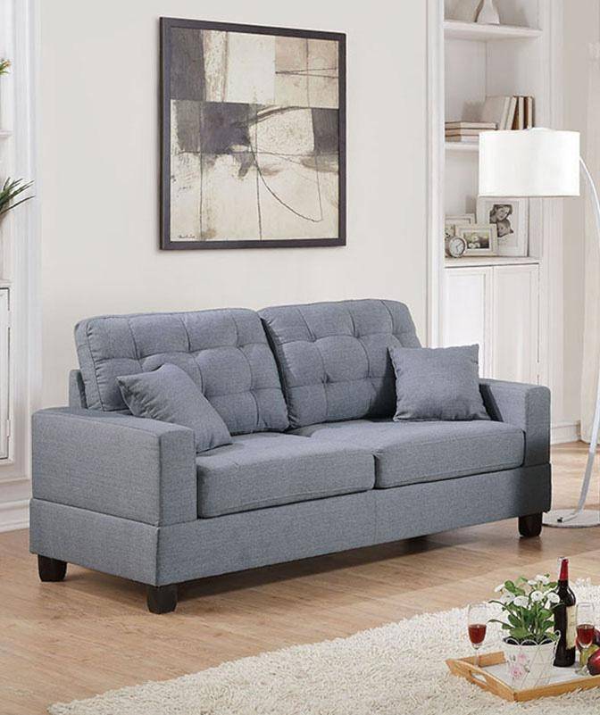 Grey upholstered sofa with tufted back cushions and square armrests