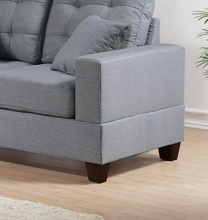 Gray fabric sectional sofa with tufted cushions and dark wood legs