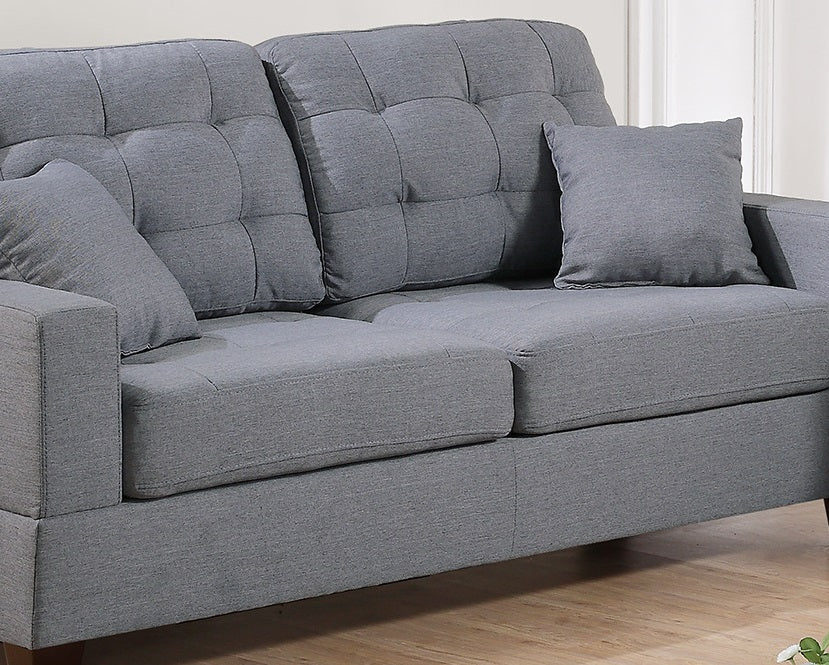 Grey fabric sofa with tufted back cushions and modern design