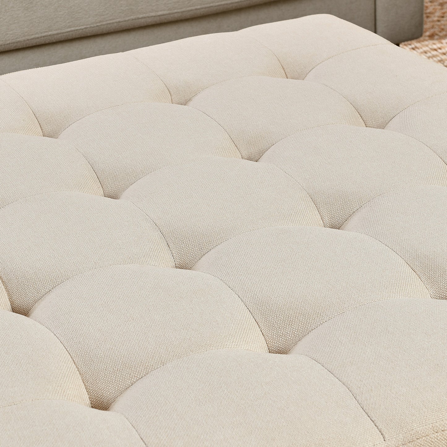 Cream upholstered ottoman with deep button tufting perfect for living rooms