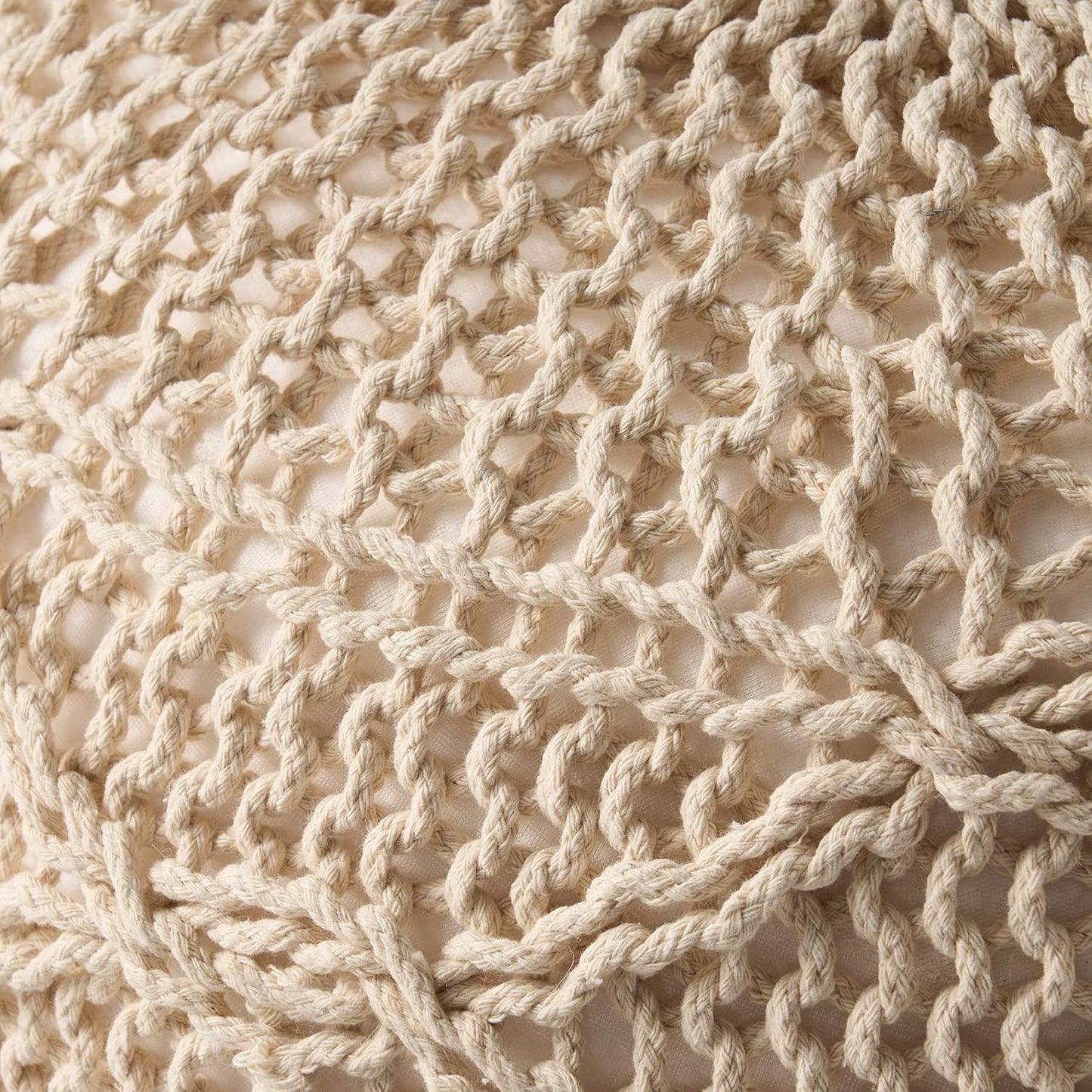 Closeup of thick creamcolored macrame rope detail on a textured surface perfect for boho decor