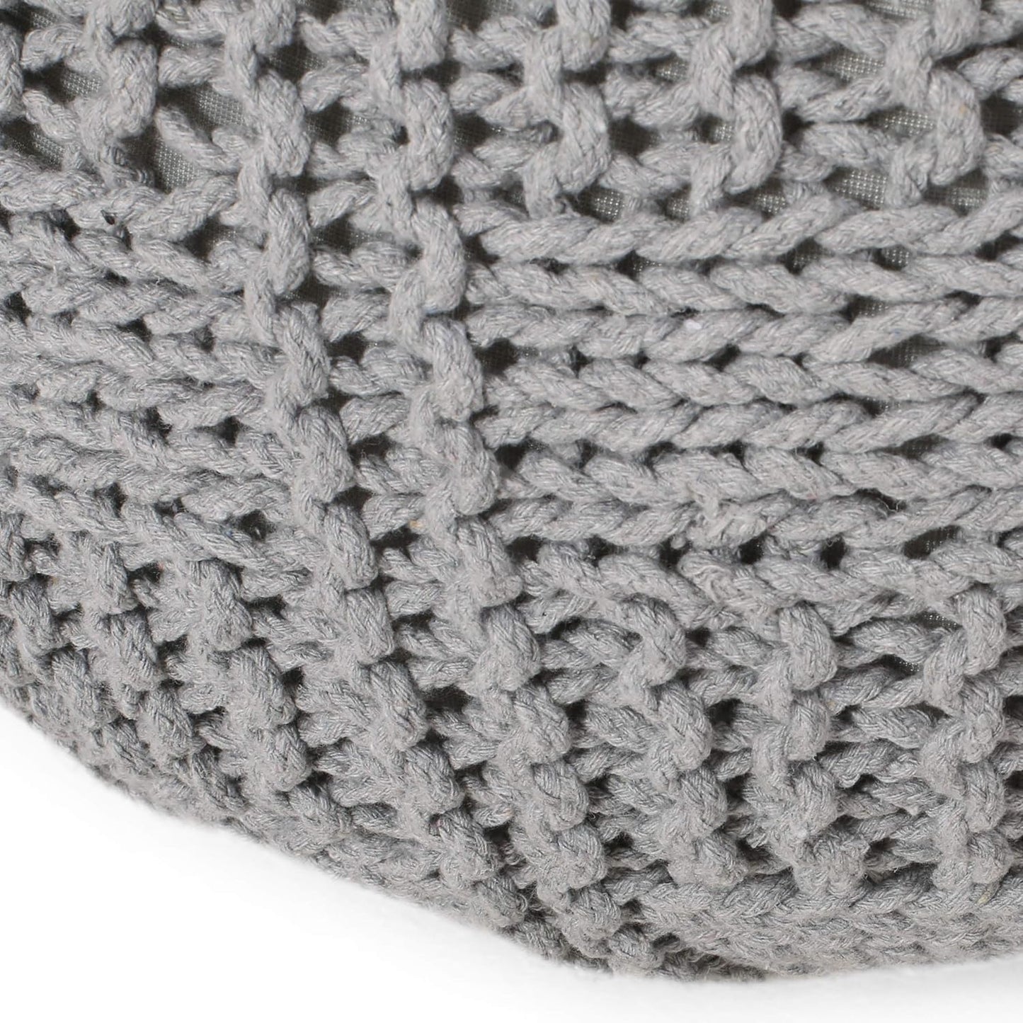 Closeup of a grey knitted pouf with a chunky cable knit texture
