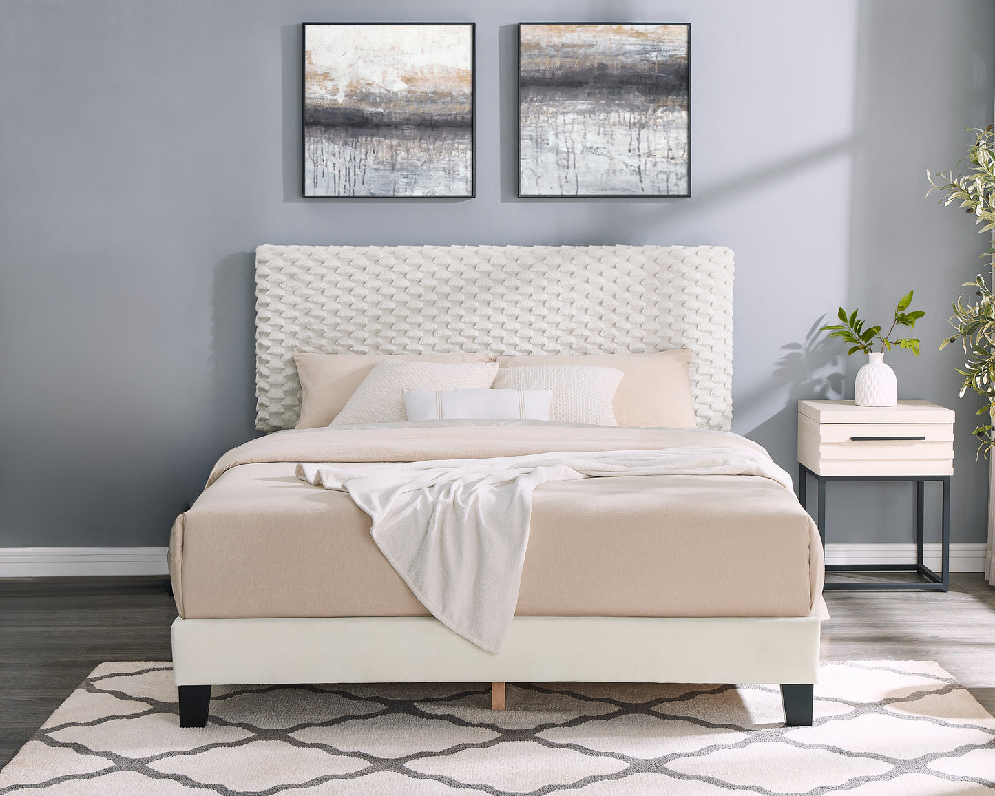 Queen size upholstered bed with textured white headboard and beige bedding