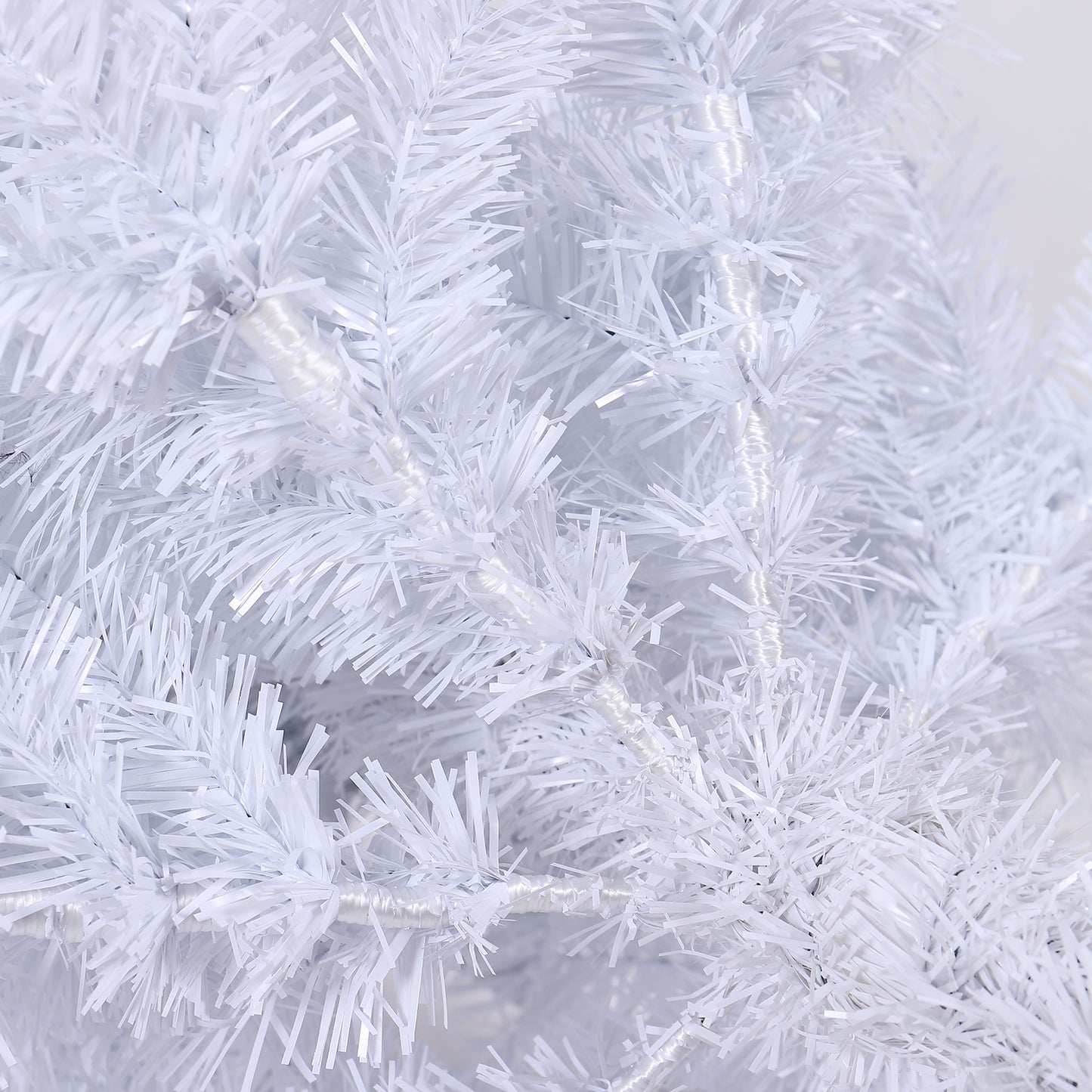 Close up of a fluffy white Christmas tree with tinsel branches for festive decor