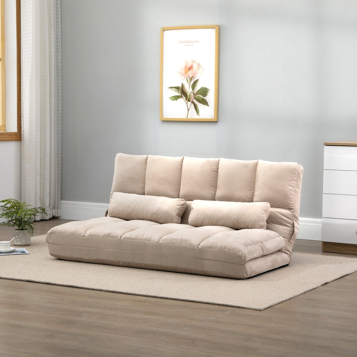 Beige convertible sofa bed with plush cushions and two accent pillows
