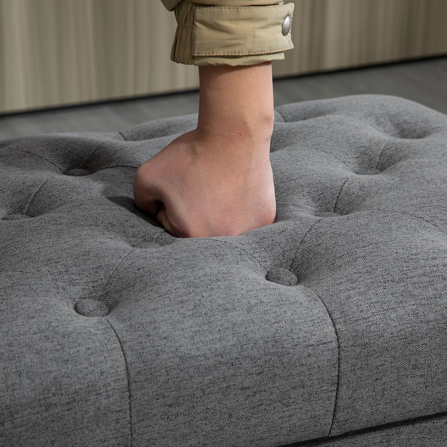 Grey upholstered ottoman with tufted design showcasing plush cushioning for comfort
