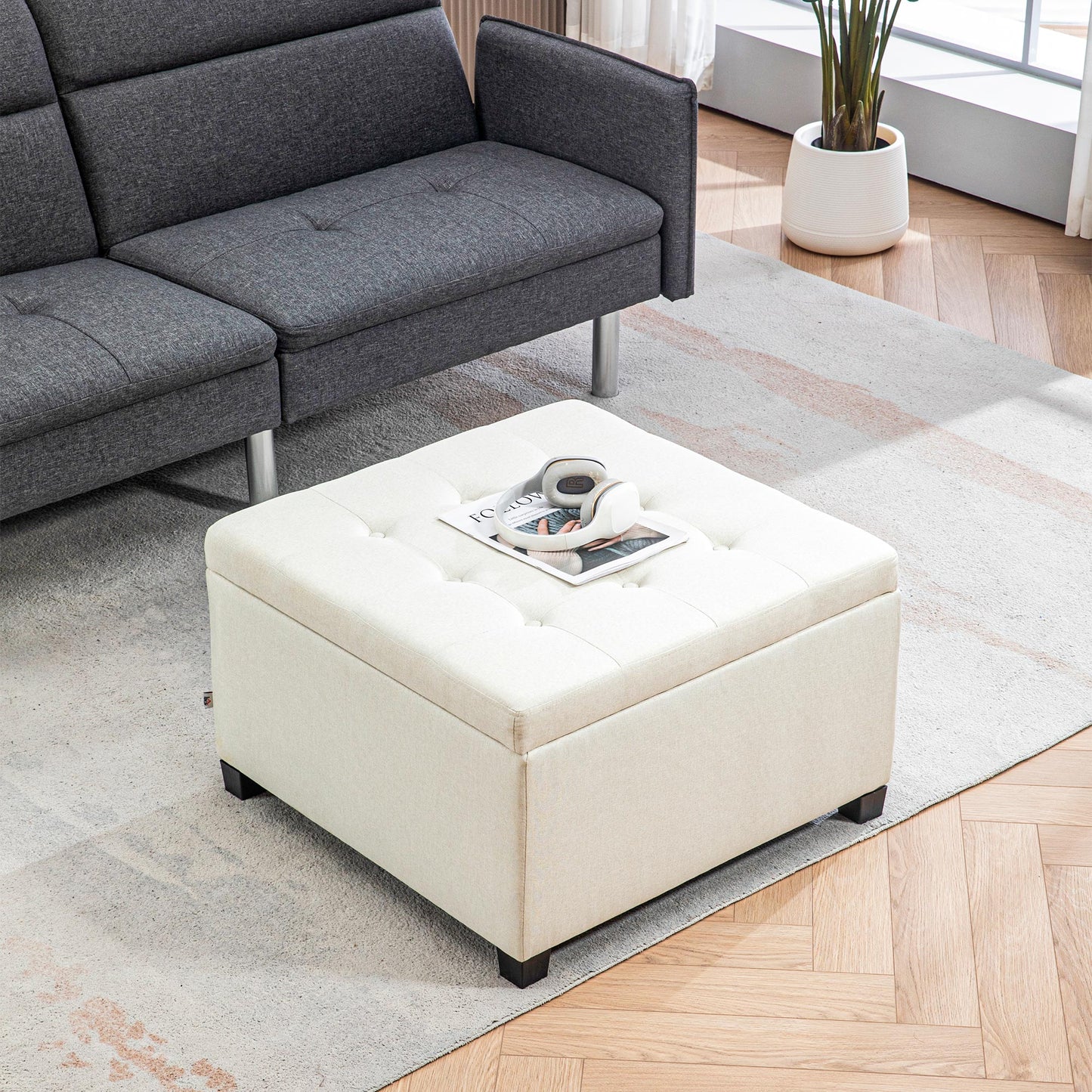 Cream upholstered storage ottoman with tufted top and wooden legs ideal for living rooms